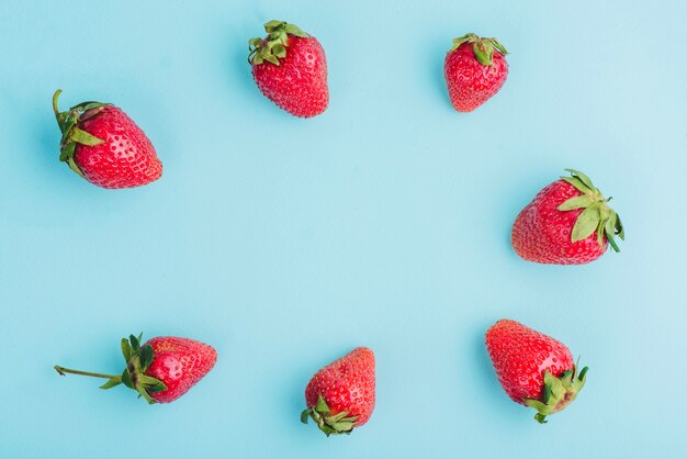 Blaue Oberfläche mit Rahmen von Erdbeeren