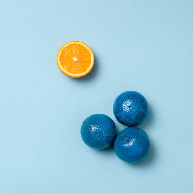 Blaue Orangen mit einer halben Orange auseinander
