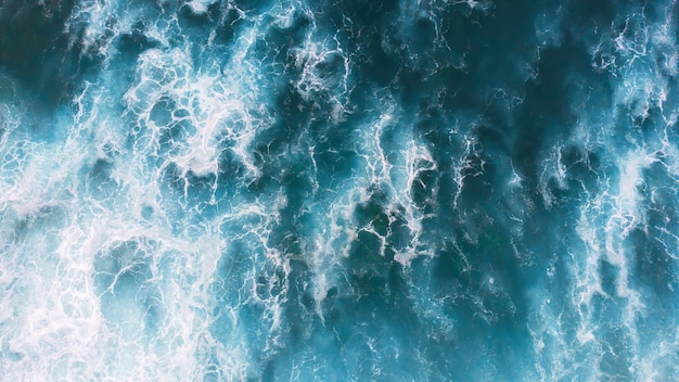 Blaue schäumende Wellen in Nordstrand in Nazare, Portugal