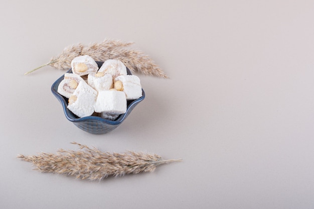 Blaue Schüssel süße Desserts mit Nüssen auf weißem Hintergrund. Foto in hoher Qualität