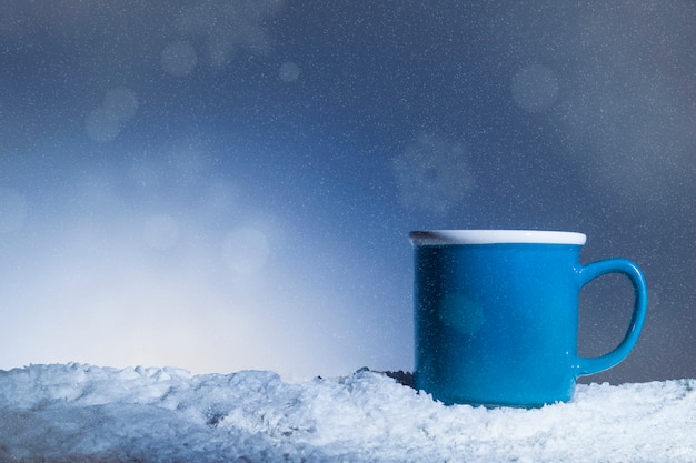 Blaue Tasse auf Schnee gelegt