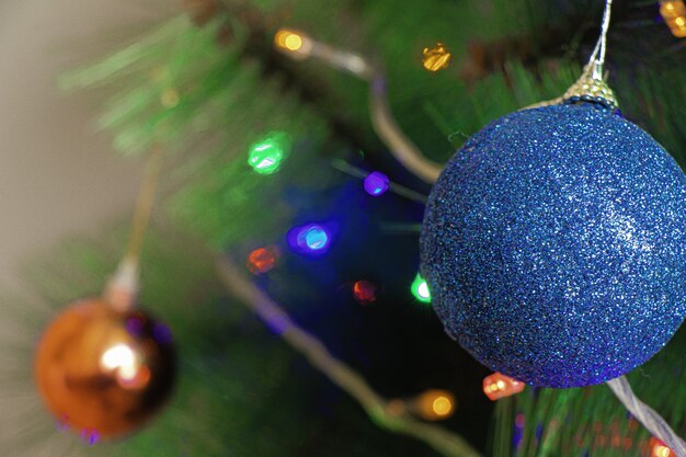 Blaue Verzierungsdekoration auf dem Weihnachtsbaum unter den Lichtern