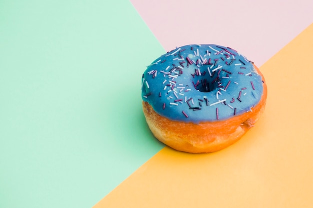 Kostenloses Foto blauer donut auf farbigem hintergrund