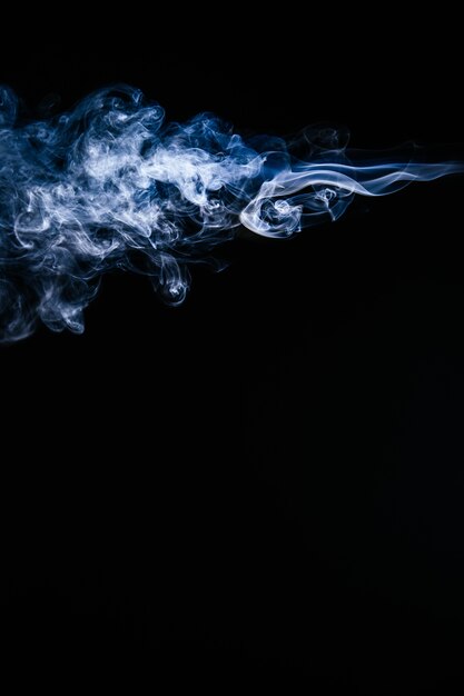 Blauer gewellter Rauch auf schwarzem Hintergrund