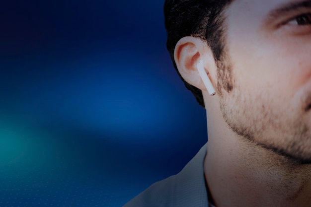 Blauer Hintergrund mit amerikanischem Mann, der Musik über drahtlose Kopfhörer hört