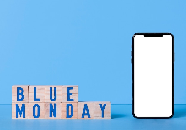 Blauer Montag mit Smartphone und Holzwürfeln