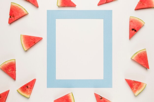 Blauer Rahmen und geschnittene saftige Wassermelone auf weißer Oberfläche