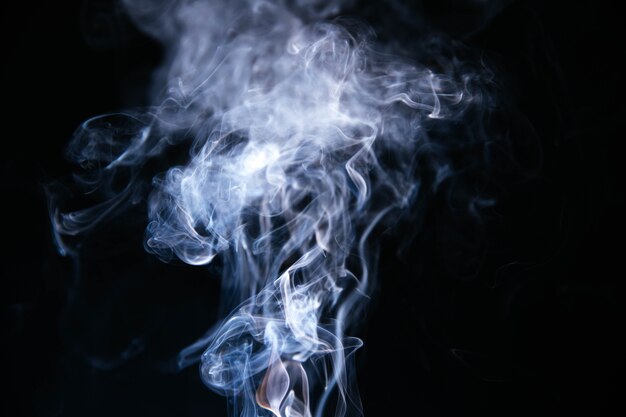 Blauer Rauch bewegt auf schwarzen Hintergrund wellenartig