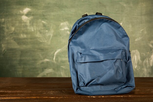 Blauer Rucksack auf Holztisch