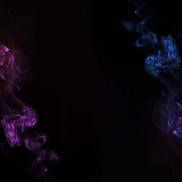 Blauer und purpurroter Raucheffekt auf schwarzen Hintergrund