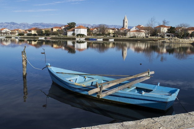 Blaues Boot entlang des Docks in einem Dorf abgebunden
