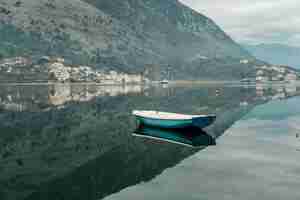 Kostenloses Foto blaues boot im golf der adria mit bergen in montenegro kotor