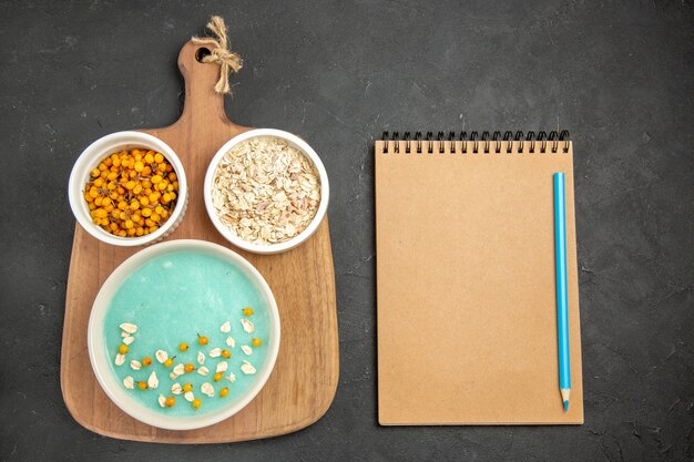 Blaues Eisdessert der Draufsicht mit rohem Müsli auf der dunklen Tafeleiscreme