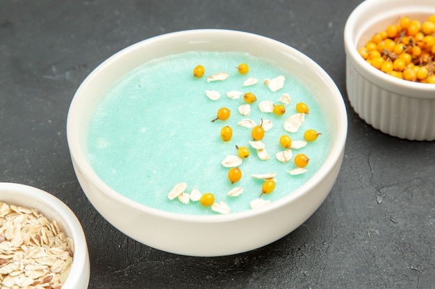 Blaues Eisdessert der Vorderansicht mit rohem Müsli auf dunklem Tischfrucht-Müsli-Frühstück