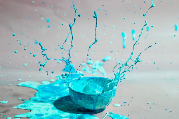 Blaues Farbenspritzen und abstrakter Hintergrund der Schale