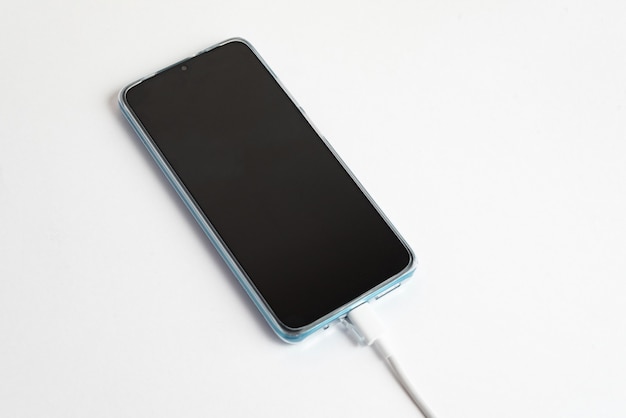 Blaues Handy mit USB-Kabel Typ C verbunden - Aufladen