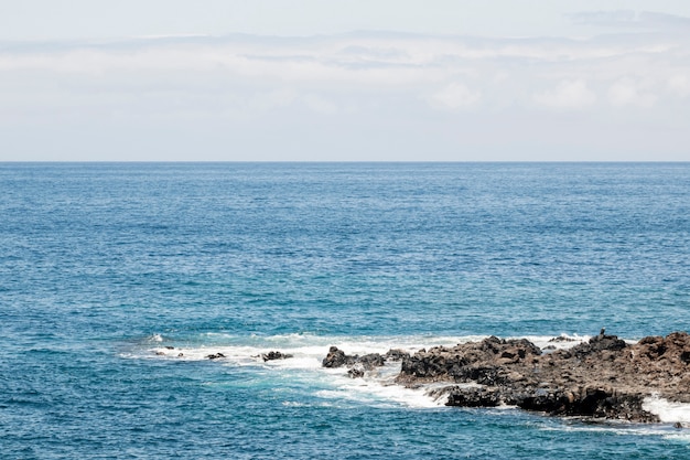 Blaues Meer mit felsigem Küstenstreifen