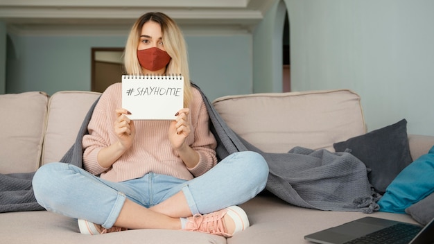 Bleiben Sie drinnen Frau, die rote medizinische Maske trägt