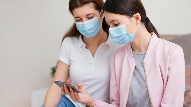 Kostenloses Foto bleiben sie drinnen frauen mit medizinischen masken