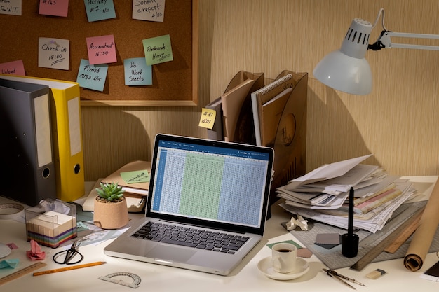 Kostenloses Foto blick auf den unordentlichen büroarbeitsplatz mit laptop-gerät