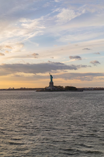 Blick auf die Freiheitsstatue aus dem Wasser bei Sonnenuntergang, New York, USA