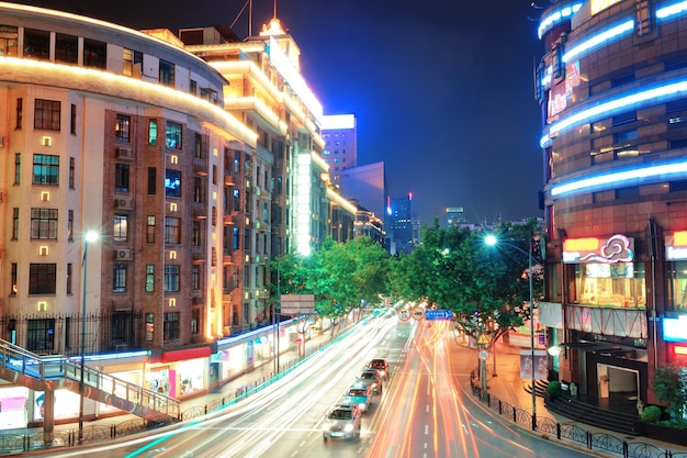 Blick auf die Straße von Shanghai mit urbaner Szene und geschäftigem Verkehr in der Abenddämmerung.