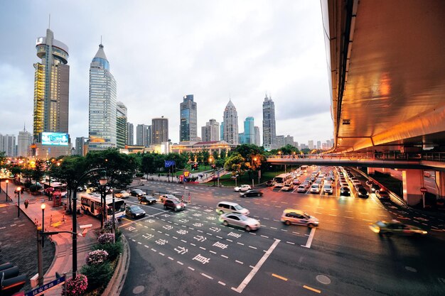 Blick auf die Straße von Shanghai mit urbaner Szene und geschäftigem Verkehr in der Abenddämmerung.