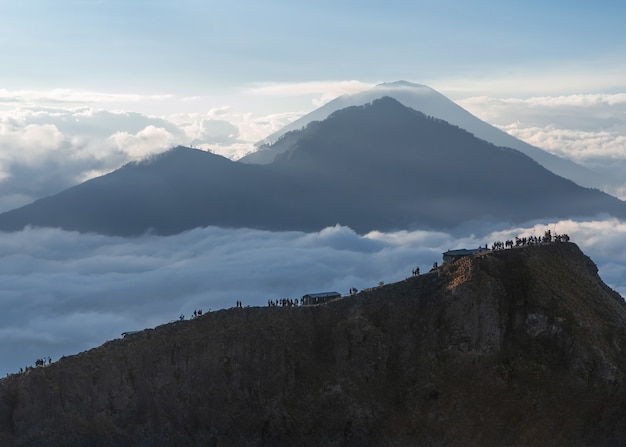 Blick auf einen Berg und Menschen, die über die Felsen in Indonesien gehen