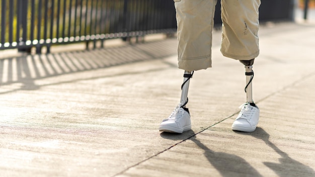 Kostenloses Foto blick auf einen gehenden mann mit beinprothesen und weißen turnschuhen