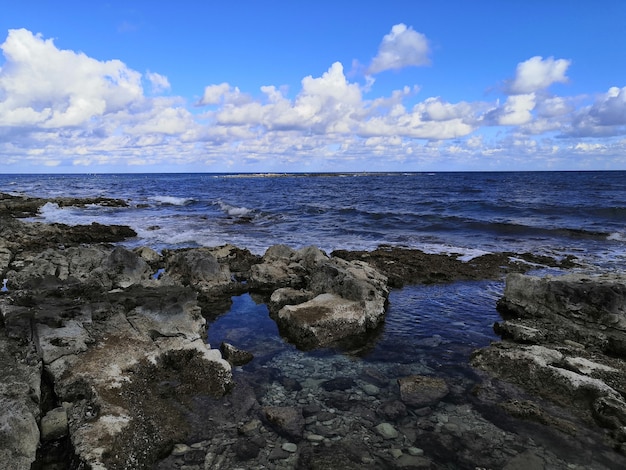 Blick auf einen schönen ruhigen Strand mit Felsen in Malta an einem sonnigen Tag eingefangen