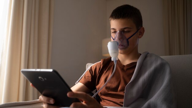 Blick auf einen Teenager, der zu Hause einen Vernebler wegen Atemwegsproblemen verwendet