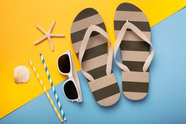 Kostenloses Foto blick auf flip-flops mit sommer-essentials und sonnenbrillen