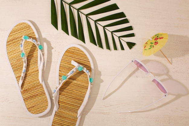 Kostenloses Foto blick auf flip-flops mit sommer-essentials und sonnenbrillen