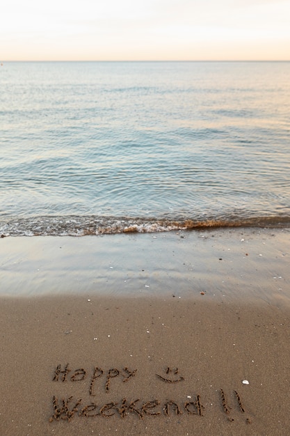 Blick auf Strandsand im Sommer mit einer darauf geschriebenen Nachricht