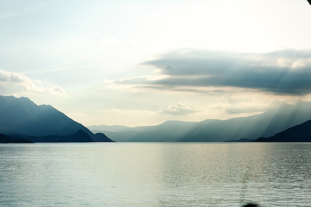 Blick von der Küste auf blaue Berge, die das Meer berühren