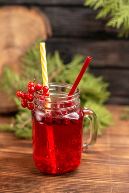 Blick von oben auf den natürlichen organischen frischen Johannisbeersaft in einer Flasche, die mit Röhren auf einem Holztisch serviert wird