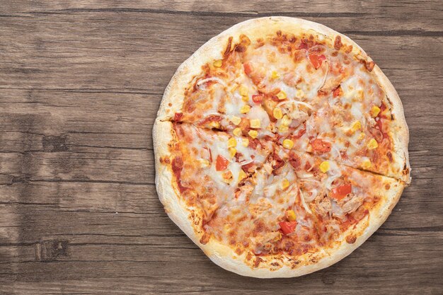 Blick von oben auf die frische Mozzarella-Pizza auf Holztisch.