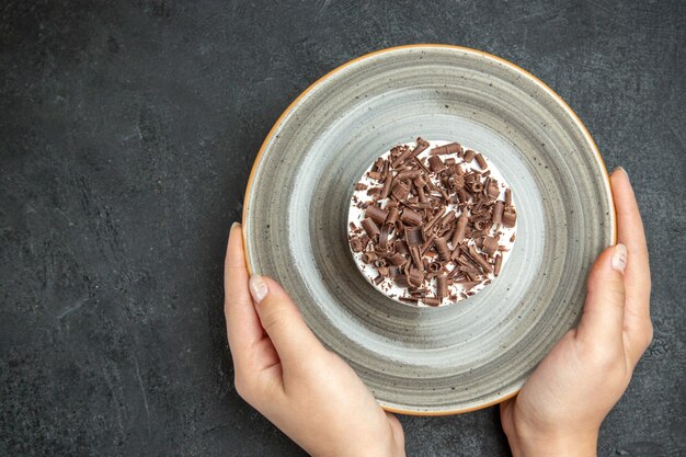 Blick von oben auf die Hände, die köstlichen cremigen hausgemachten Cupcake halten?