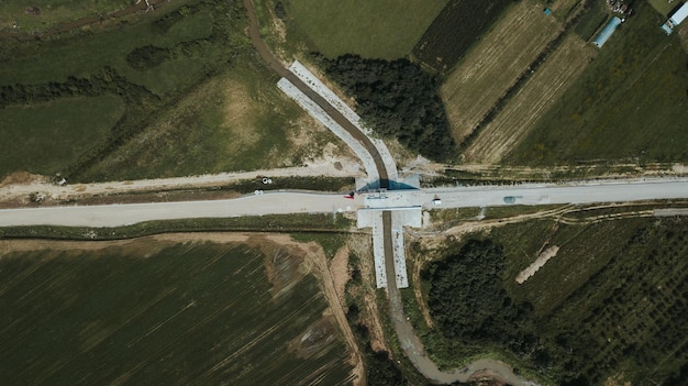 Blick von oben auf eine im Bau befindliche Straße im Bezirk Brcko, umgeben von Feldern, Bosnien und Herzegowina