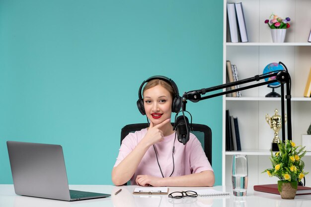 Blogger-Journalist junges süßes blondes Mädchen, das Video auf dem Computer im Büro aufnimmt, lächelt