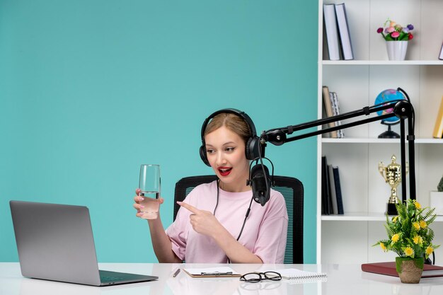 Blogger-Journalistin im Büro, junges süßes blondes Mädchen, das Videos auf einem Computer mit Glas aufnimmt