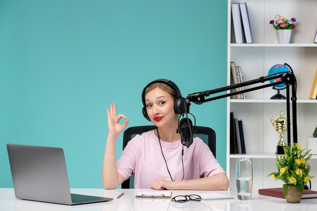 Blogger-Journalistin, junges süßes blondes Mädchen, das Videos auf dem Computer im Büro aufzeichnet, zuversichtlich