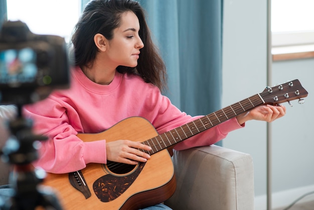 Blogger spielt Gitarre vor der Kamera