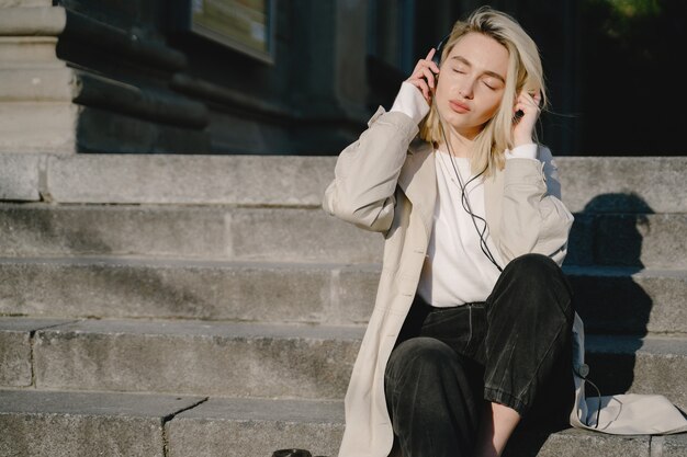 Blond hören Musik in einer Sommerstadt