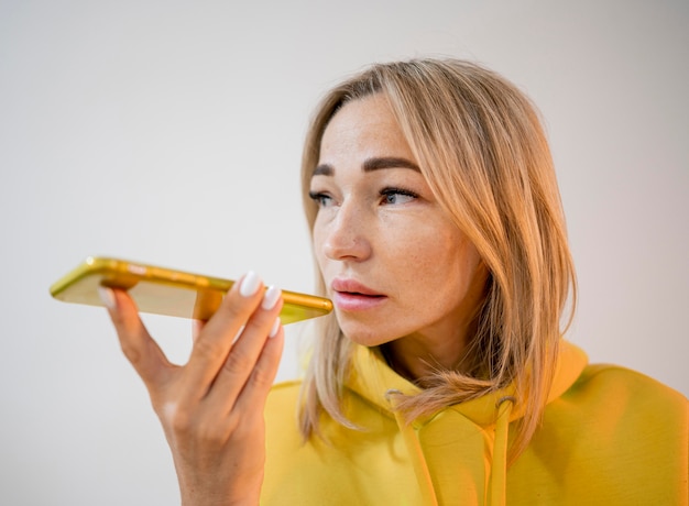 Blonde asiatische Frau, die ein Stück Pizza hält