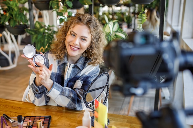 Kostenloses Foto blonde bloggerin zeigt, wie man kosmetik schminkt und verwendet