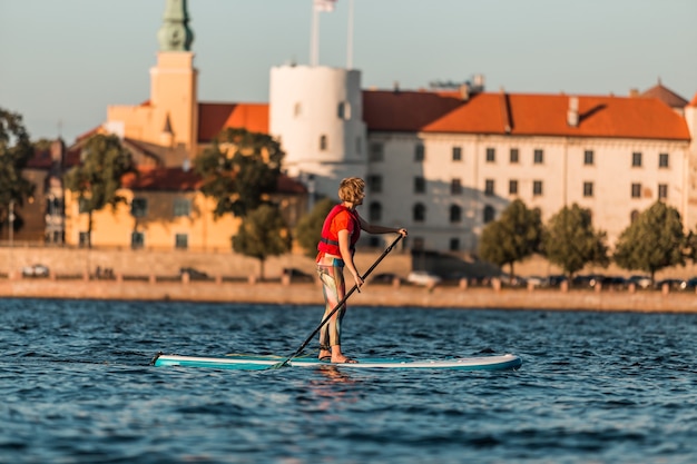 Blonde Frau auf Paddleboard in Old Riga, Lettland