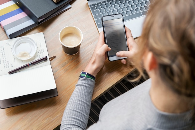 Blonde Frau, die an ihrem Telefon simst