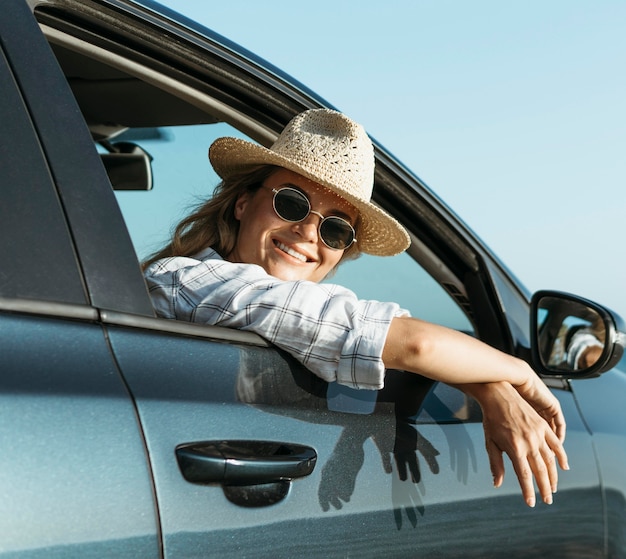 Blonde frau, die aus autofenster schaut