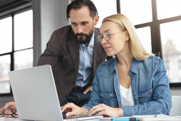 Blonde Frau, die Gespräch mit Arbeitskollege hat